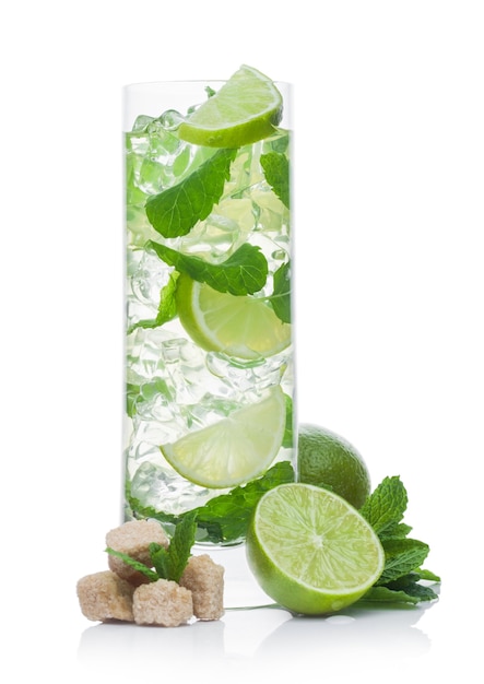 Verre à whisky d'été Mojito cocktail alcoolisé avec glaçons menthe et citron vert sur fond blanc avec sucre de canne et citron vert brut