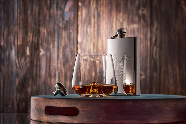 Verre de whisky et une fiole sur la table en bois