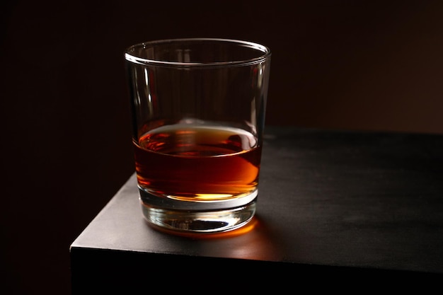 Un verre de whisky avec de la glace sur une table en bois