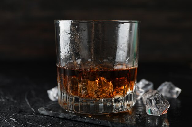 Verre de whisky et de glaçons sur fond noir