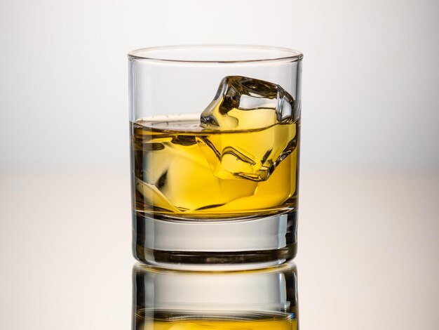 Verre de whisky sur les rochers sur une surface réfléchissante