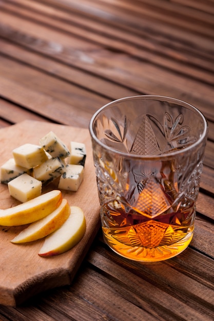 Verre de whisky sur une table en bois avec une collation