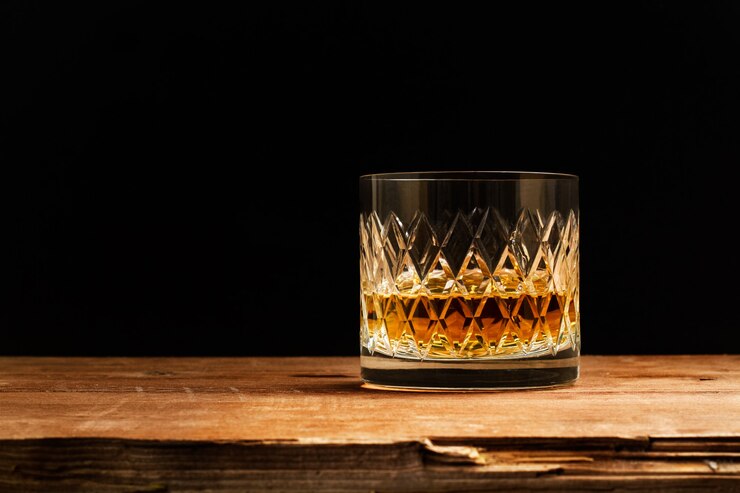 Photo un verre de whisky sur une table en bois sur une sombre