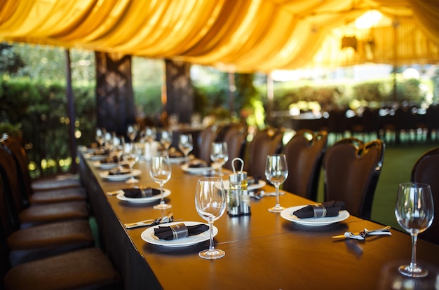 La verrerie étincelante se dresse sur une longue table préparée pour le dîner de mariage