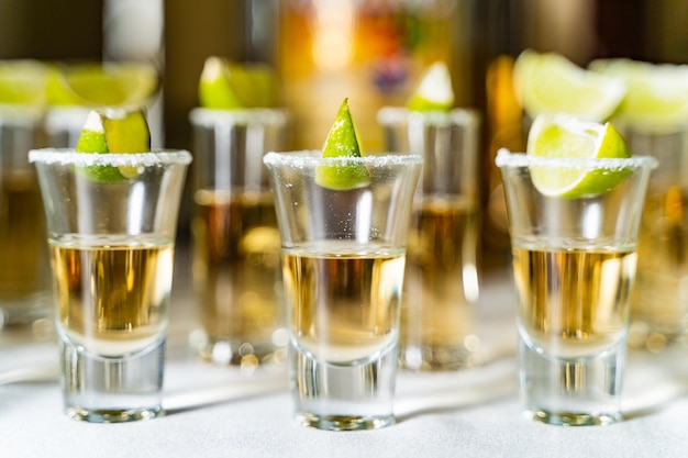 Verres d'alcool et de citron vert sur la table du restaurant Mise au point sélective et espace de copie coups de tequila vodkawhisky rhum au citron