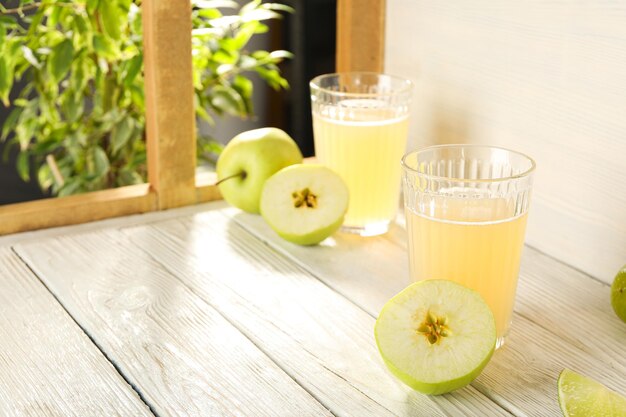 Verres avec des bâtons de cannelle de cidre de pomme et une fenêtre sur un fond clair pour le texte