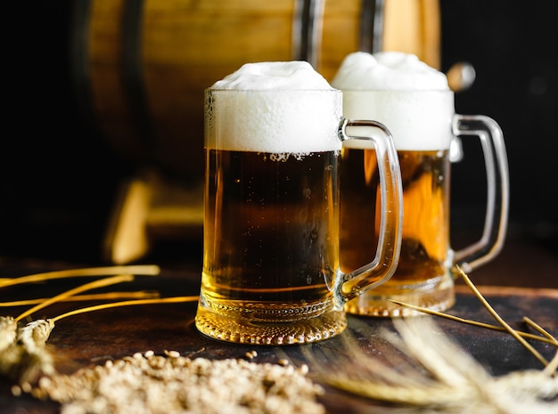 Photo verres à bière et épices de blé sur une vieille table en bois rustique sur fond noir