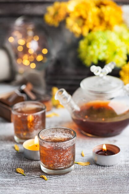 Verres avec des bougies allumées et théière