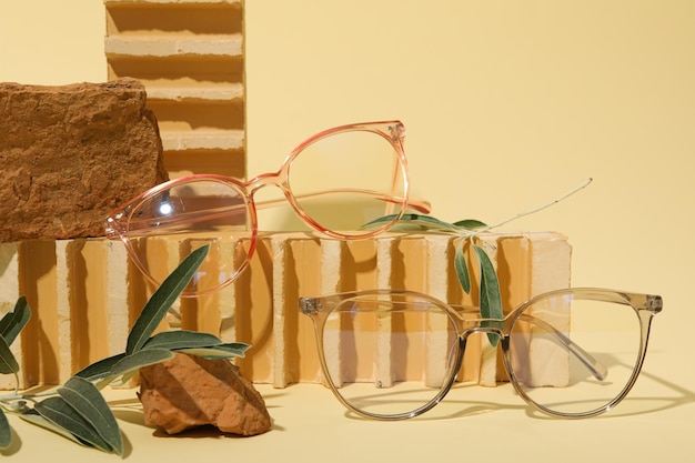 Des verres et des branches d'olivier sur des pierres sur un fond beige