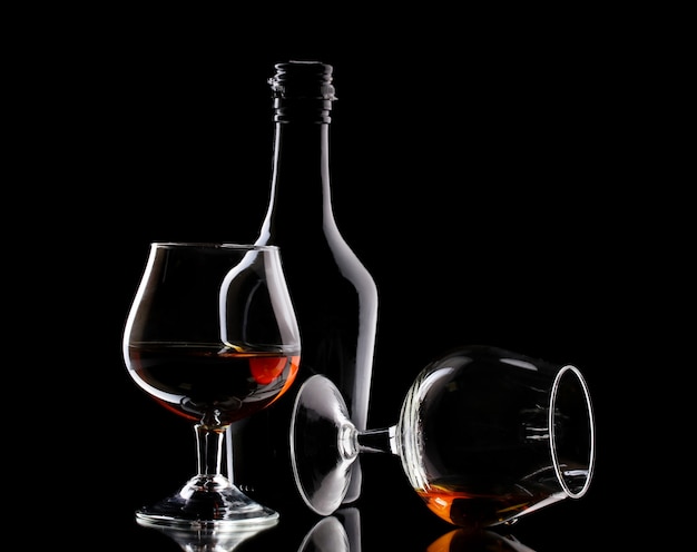 Verres de brandy et bouteille sur table noire