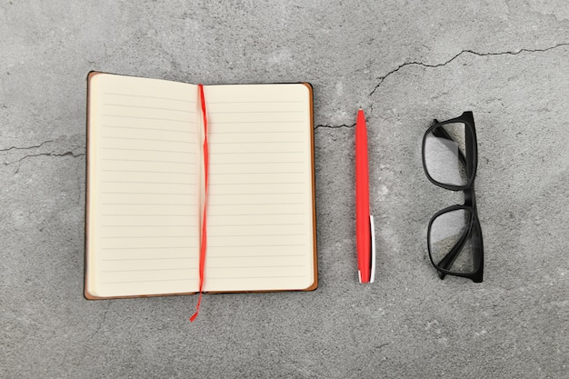 Verres avec carnet sur fond gris