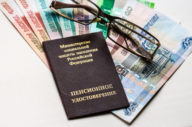 Verres de certificat de pension russe et billets de banque en roubles russes