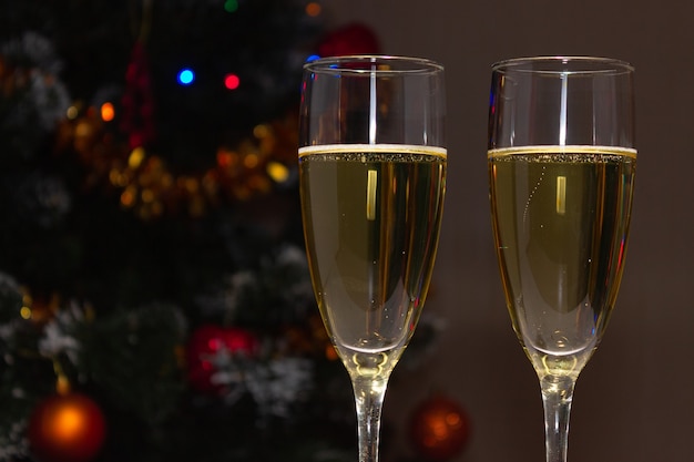 Verres de champagne au-dessus d'un arbre de Noël décoré