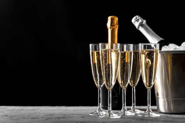 Verres de champagne avec une bouteille de champagne dans un seau