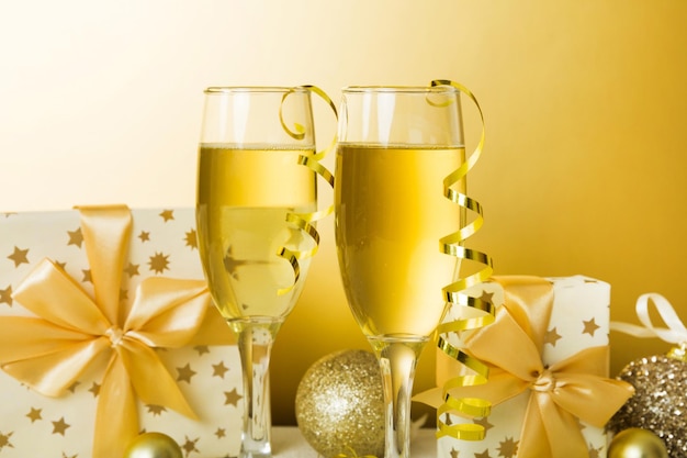 Verres à champagne et décor de noël sur fond de vacances coloré Décorations du nouvel an à plat