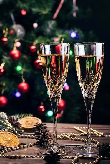 Verres de champagne sur fond de Noël avec un sapin de Noël décoré et une guirlande