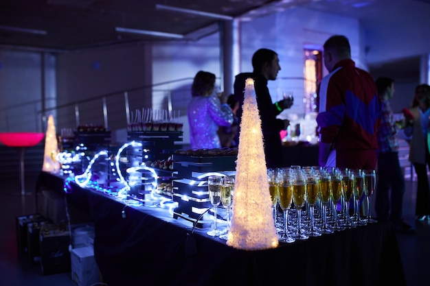 Photo verres de champagne magnifiquement brillants sur la table dans le contexte d'une atmosphère festive avec éclairage au néon.