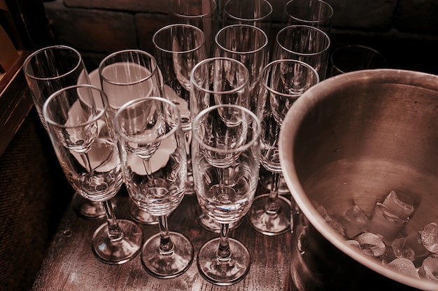 Photo verres à champagne vides à côté d'un seau à glace en métal