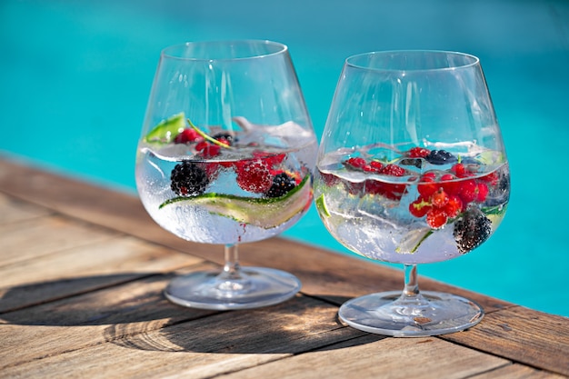 Verres à cocktail aux fruits rouges près de la piscine