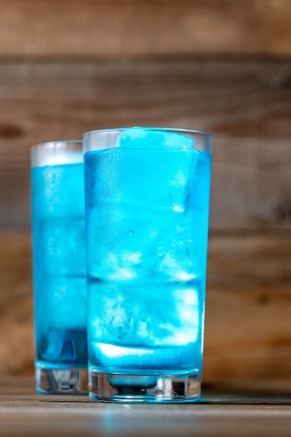 Verres de cocktail Blue Lagoon sur table en bois