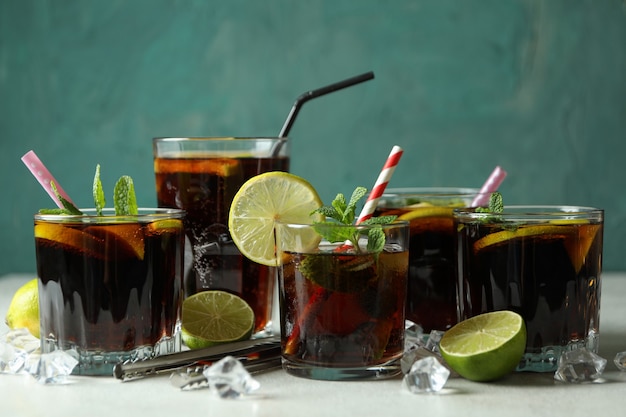 Verres de Cuba Libre sur table texturée blanche contre surface verte