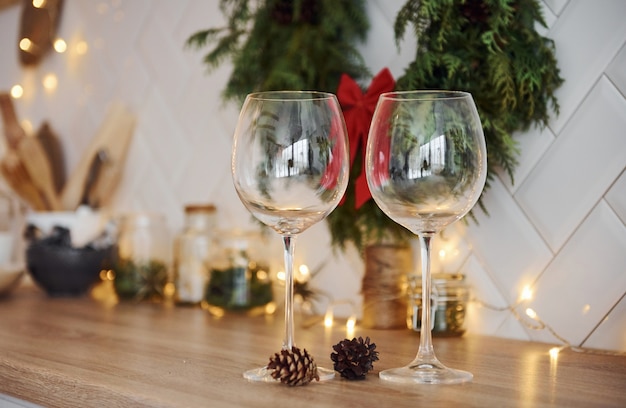 Verres et décorations de Noël dans la chambre. Guirlandes lumineuses et lumières.