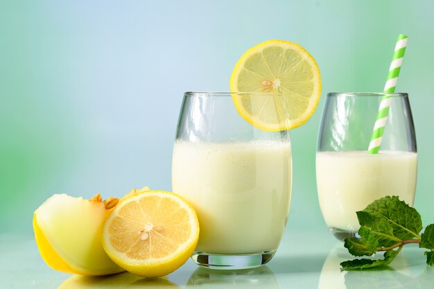 verres avec du jus de melon avec du lait et du citron sicilien sur une surface réfléchissante