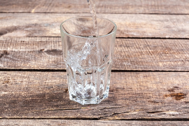 Verres d'eau sur une table en bois.