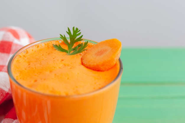 Verres de jus de carotte avec des légumes sur la table se bouchent