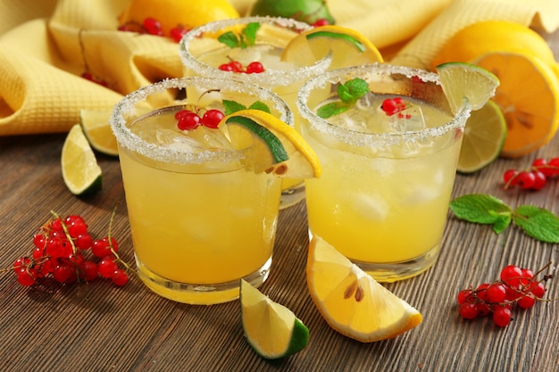 Verres de jus de citron avec des groseilles rouges sur une table en bois libre