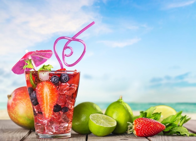 Verres de jus de fruits et légumes avec des fruits sur fond blanc