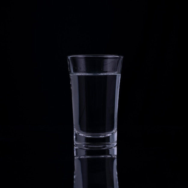 Verres à liqueur avec de la vodka sur fond noir