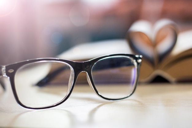 Verres noirs sur le fond du livre à la lumière du soleil