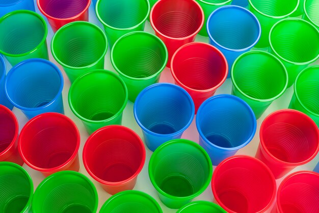 Verres en plastique multicolores isolés sur blanc