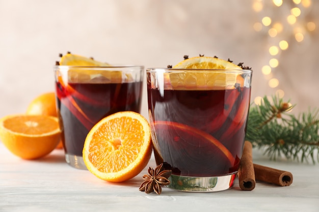 Verres de savoureux vin chaud à l'orange sur une table en bois blanc