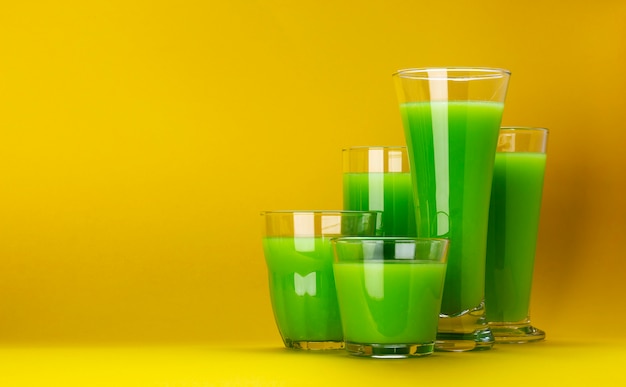 Verres à smoothie vert bio isolés sur fond jaune