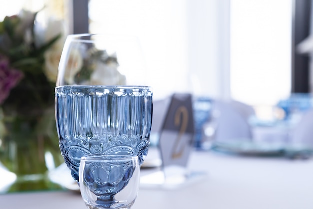 Verres sur la table de mariage sur un fond clair, gros plan