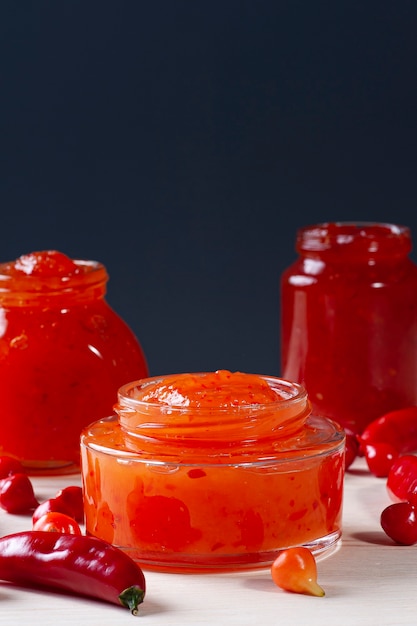 Verres transparents de confiture de poivre sur table en bois.