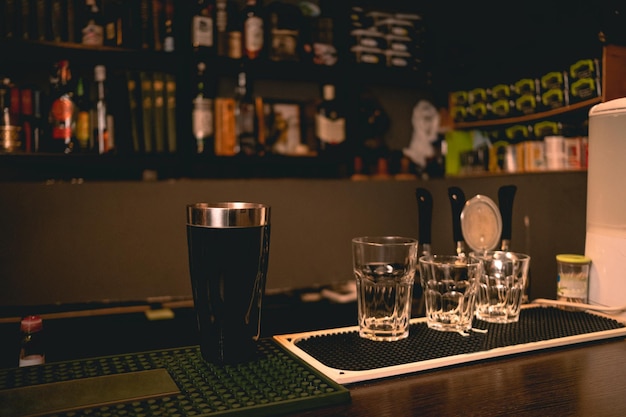 Verres vides et shaker debout sur le comptoir du bar