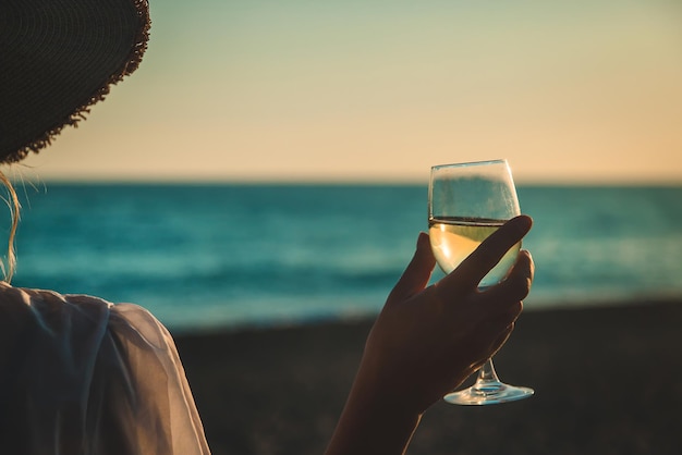 Verres à vin au coucher du soleil sur la plage. Mise au point sélective.