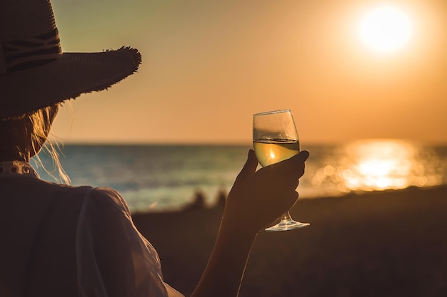 Verres à vin au coucher du soleil sur la plage. Mise au point sélective.