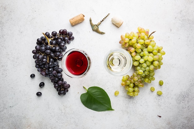 Verres de vin blanc et rouge avec des raisins mûrs sur fond de pierre, vue de dessus