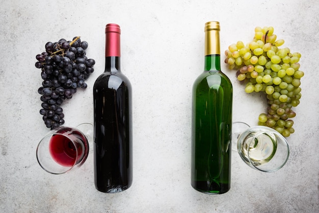 Verres de vin blanc et rouge avec des raisins mûrs sur fond de pierre, vue de dessus