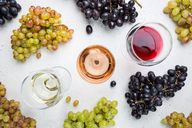 Verres à vin blanc rouge et rose sur fond blanc vue de dessus