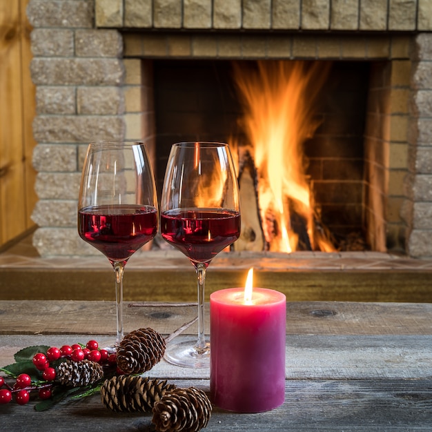 Verres de vin et bougie près de la cheminée