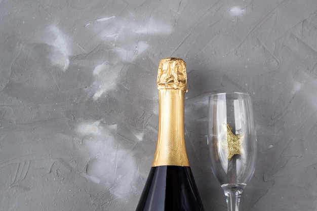 Verres à vin et bouteille de champagne sur fond gris Mise à plat pour le concept de célébration de Noël