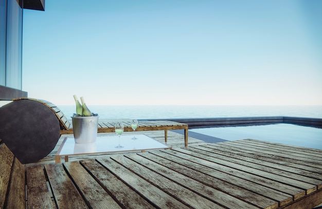 Des verres à vin et des bouteilles de vin sont placés sur la table avec des sièges. Vue mer côté piscine