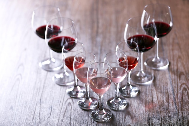 Verres à vin avec du vin blanc rouge et rose sur une table en bois agrandi