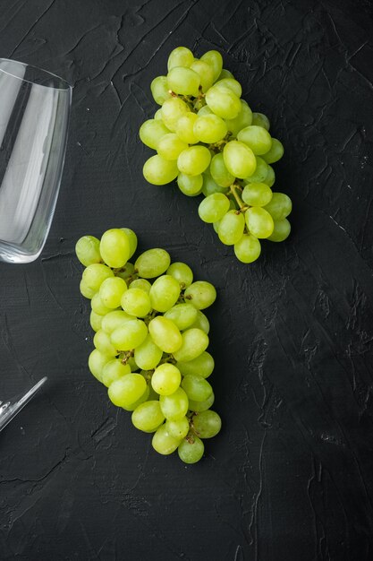 Verres à vin avec ensemble de raisins, sur fond de pierre noire, vue de dessus à plat