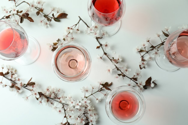 Verres de vin et fleurs de cerisier sur fond blanc